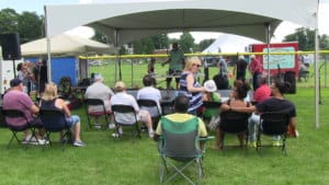 a group of people in chairs watching a demonstration on a stage in upstate ny